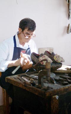 Calzolaio lavora alle scarpe tradizionali del costume femminile